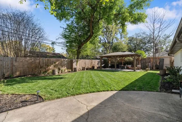 a view of a yard with a house and a street