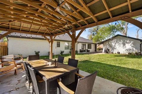 a view of a patio with table and chairs with wooden floor and fence