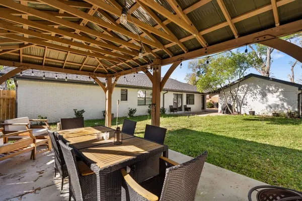 a view of a patio with table and chairs with wooden floor and fence