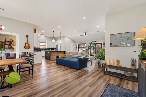 a living room with furniture and a wooden floor