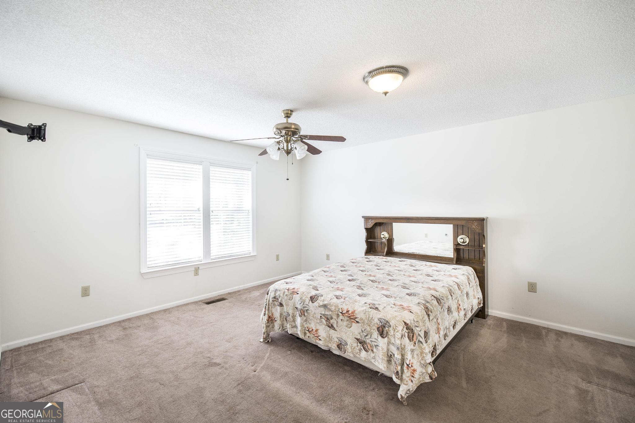 240 Mossland Drive Perry, GA 31069 - Photo 11 of 36 a bedroom with a bed and a chandelier