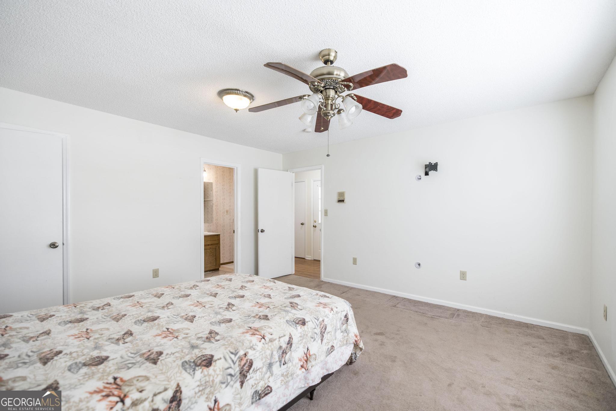 240 Mossland Drive Perry, GA 31069 - Photo 12 of 36 a bedroom with a bed and a chandelier