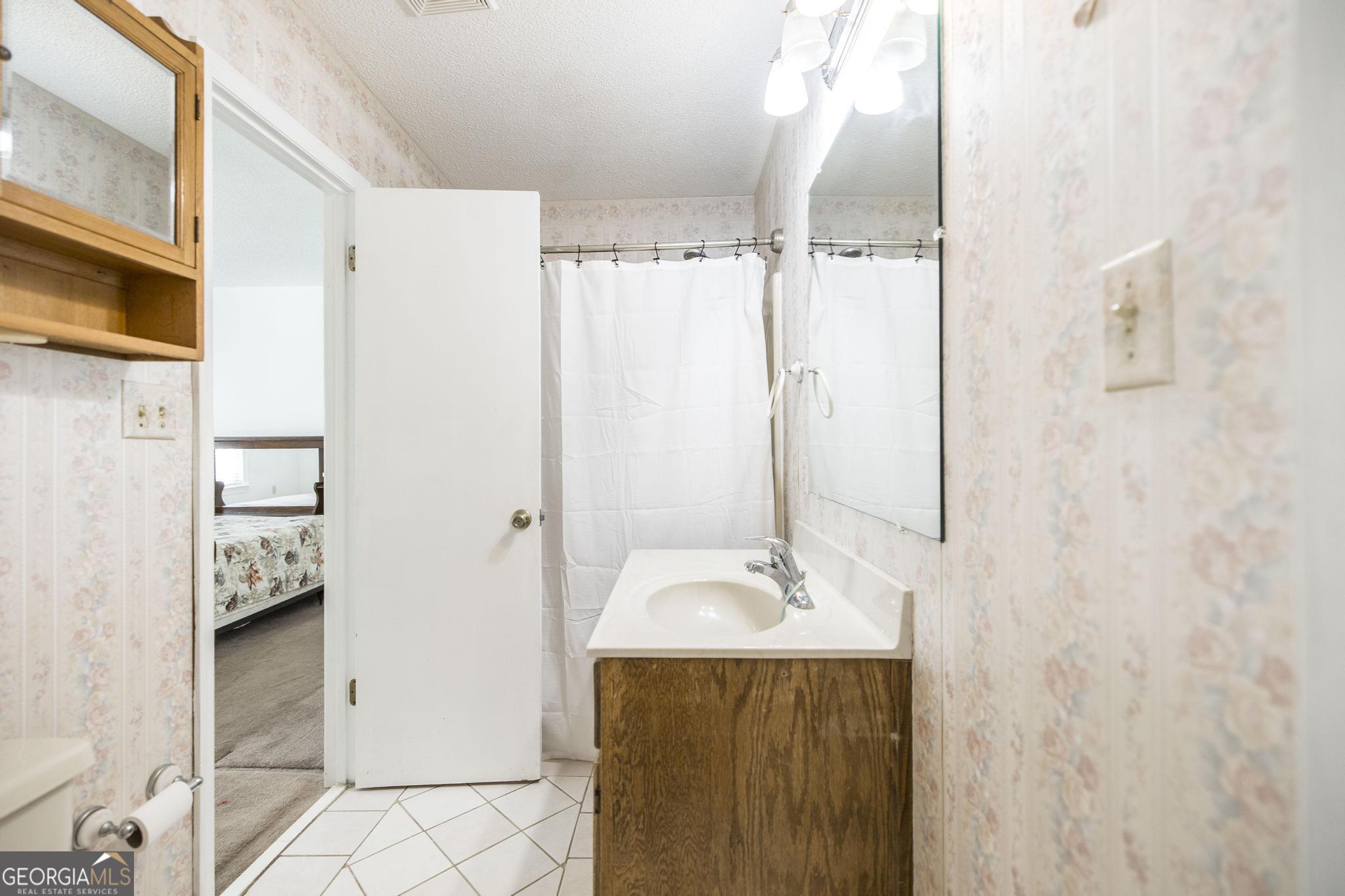 240 Mossland Drive Perry, GA 31069 - Photo 13 of 36 a bathroom with a sink a mirror and shower