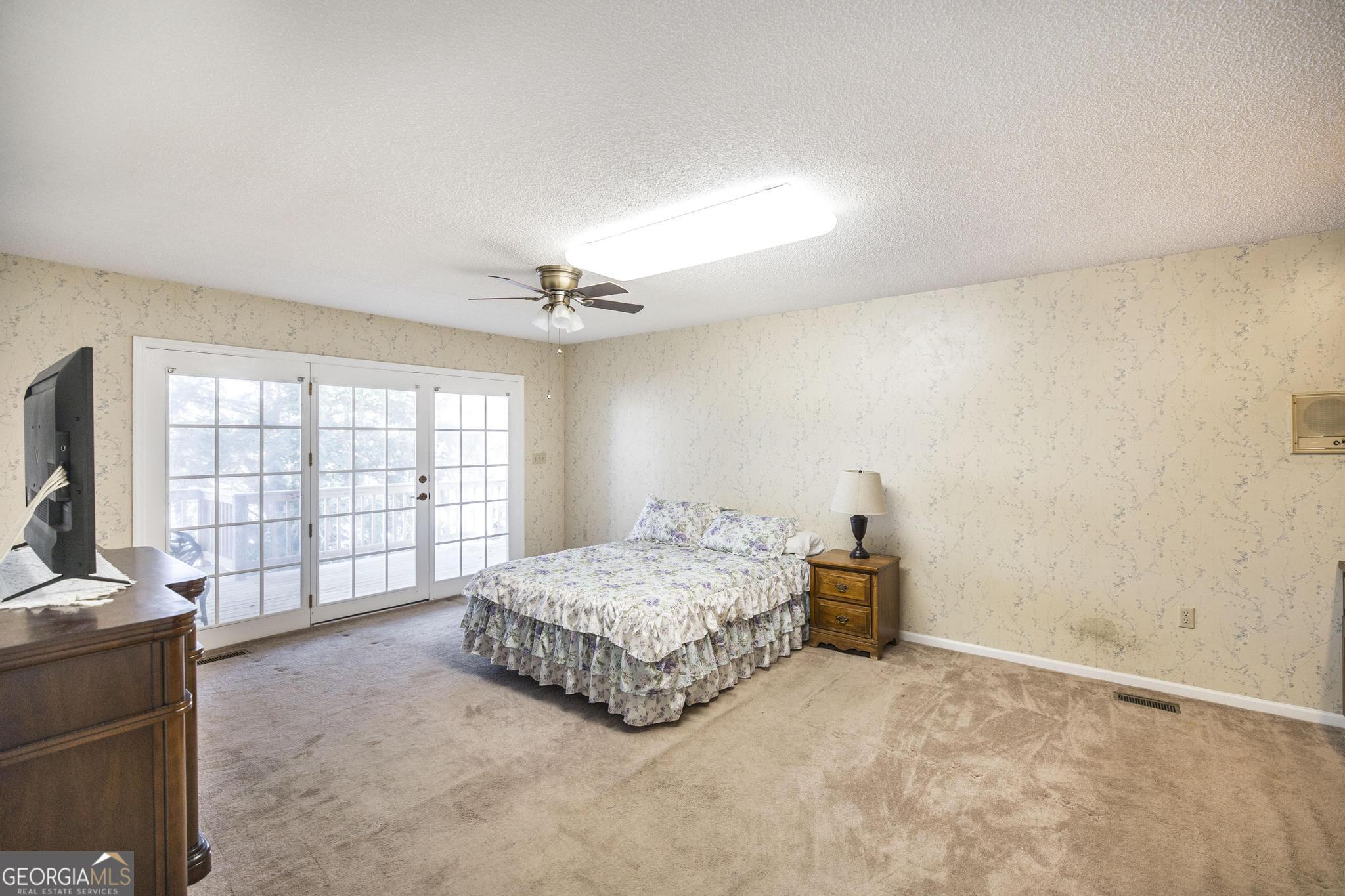 240 Mossland Drive Perry, GA 31069 - Photo 22 of 36 a spacious bedroom with a bed and wooden floor