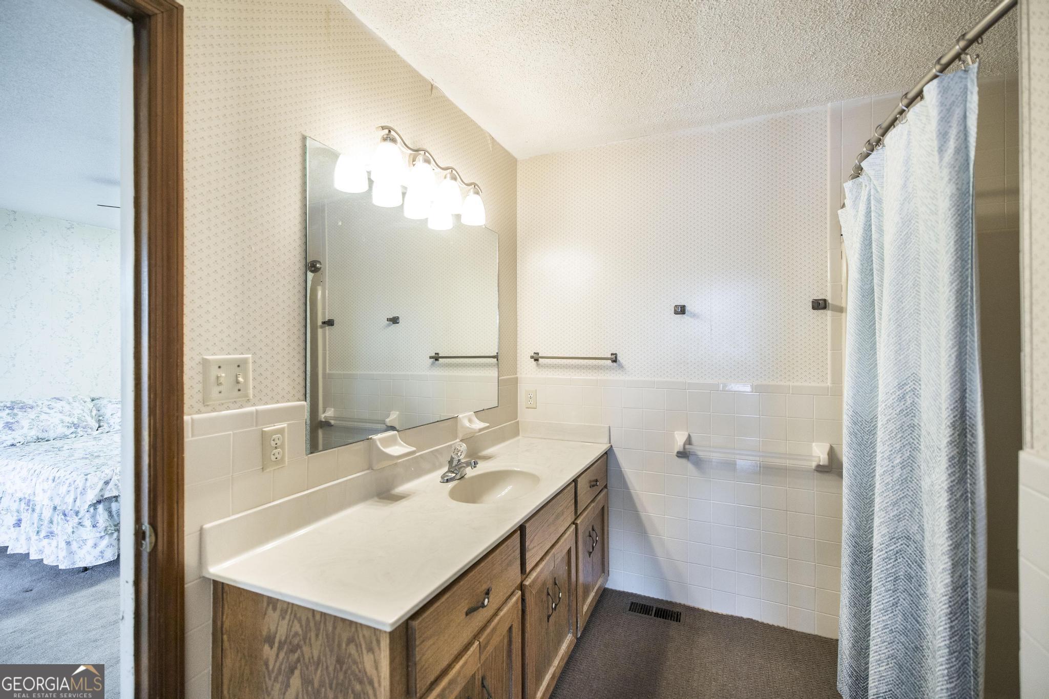 240 Mossland Drive Perry, GA 31069 - Photo 24 of 36 a bathroom with a sink a mirror and a shower