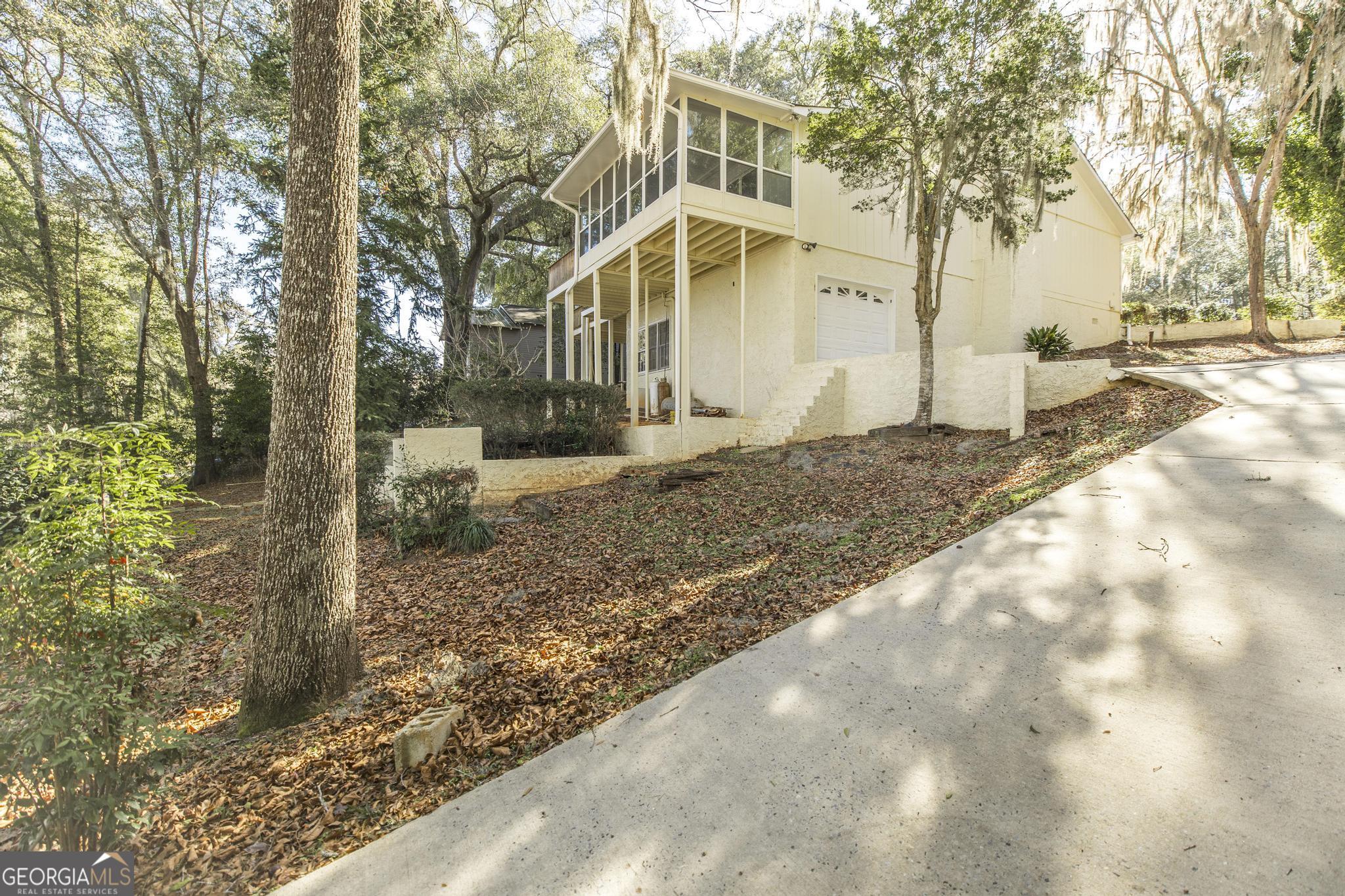 240 Mossland Drive Perry, GA 31069 - Photo 34 of 36 a view of a white house next to a yard with large trees