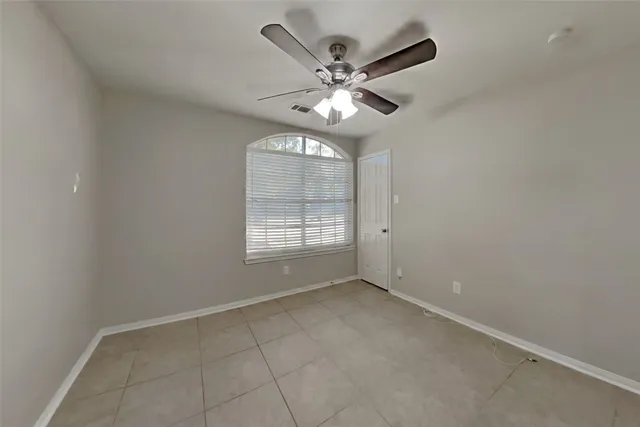 an empty room with a window and a fan