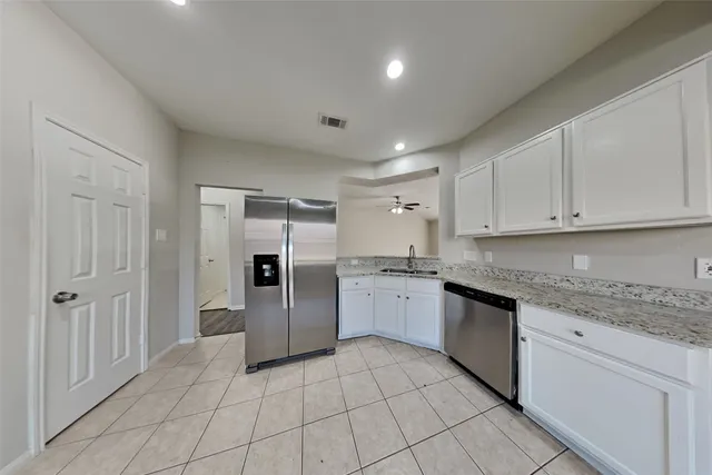 a large kitchen with cabinets and stainless steel appliances