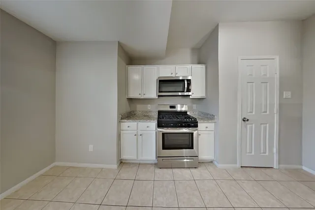 a kitchen with stainless steel appliances a stove a microwave and a sink