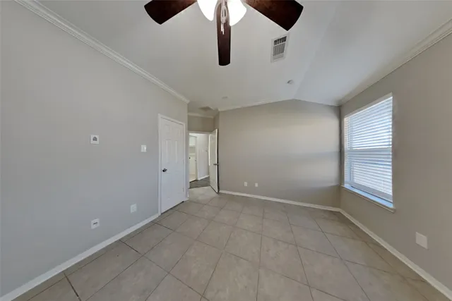 an empty room with ceiling fan and window