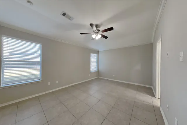 a view of an empty room with a ceiling fan and window