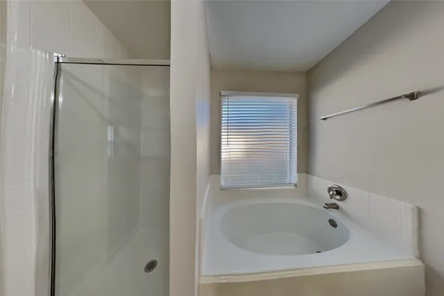 a bathroom with a tub and a shower