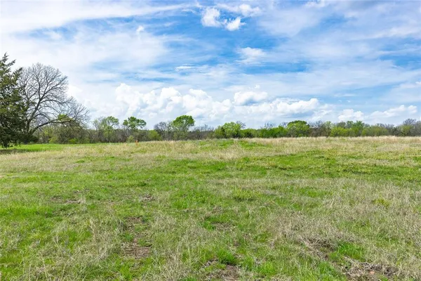 a view of a green field with wooden fence