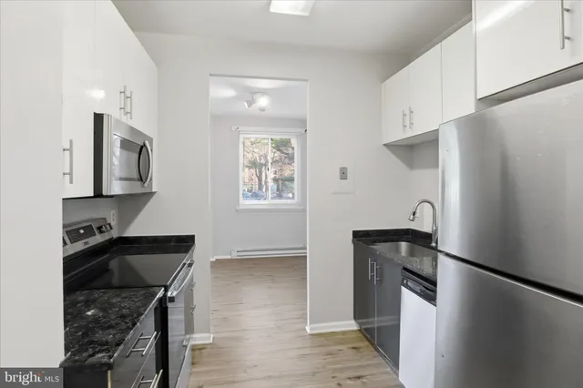 a kitchen with granite countertop a refrigerator stove and sink