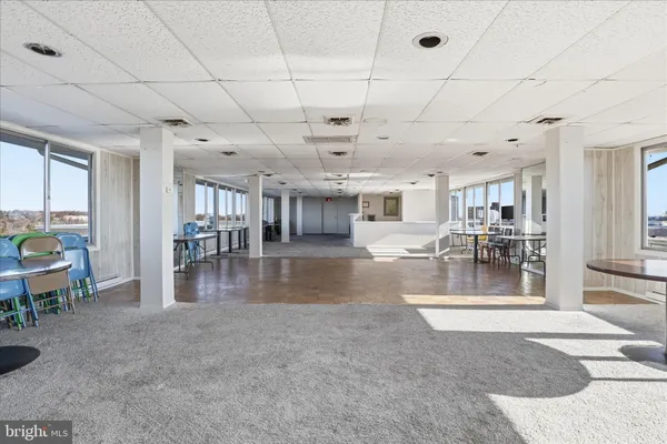 a view of a livingroom with dining area a chandelier fan and windows