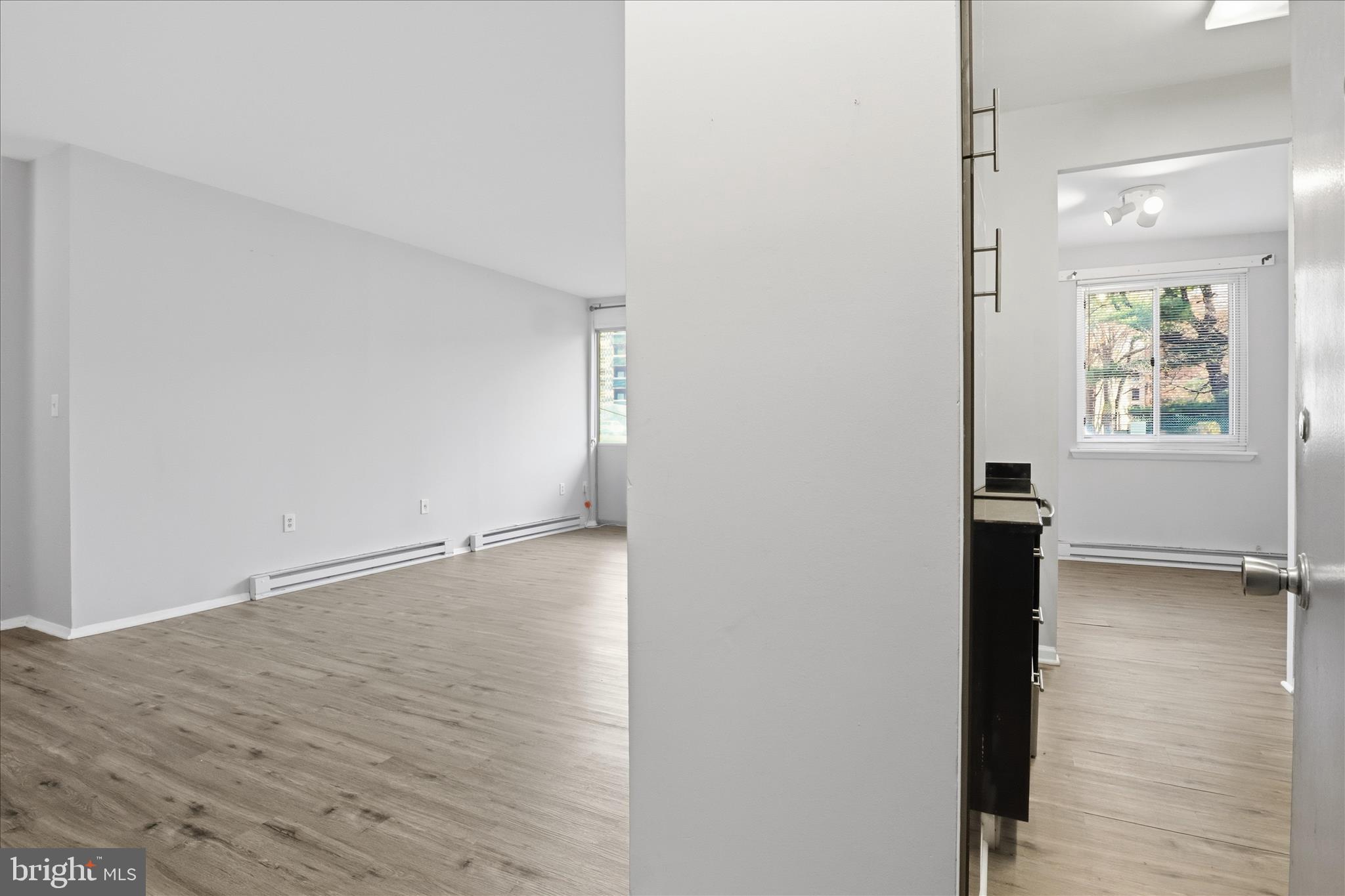 3245 Rio Drive, Unit 107 Falls Church, VA 22041 - Photo 3 of 32 a view of an empty room with wooden floor and a window