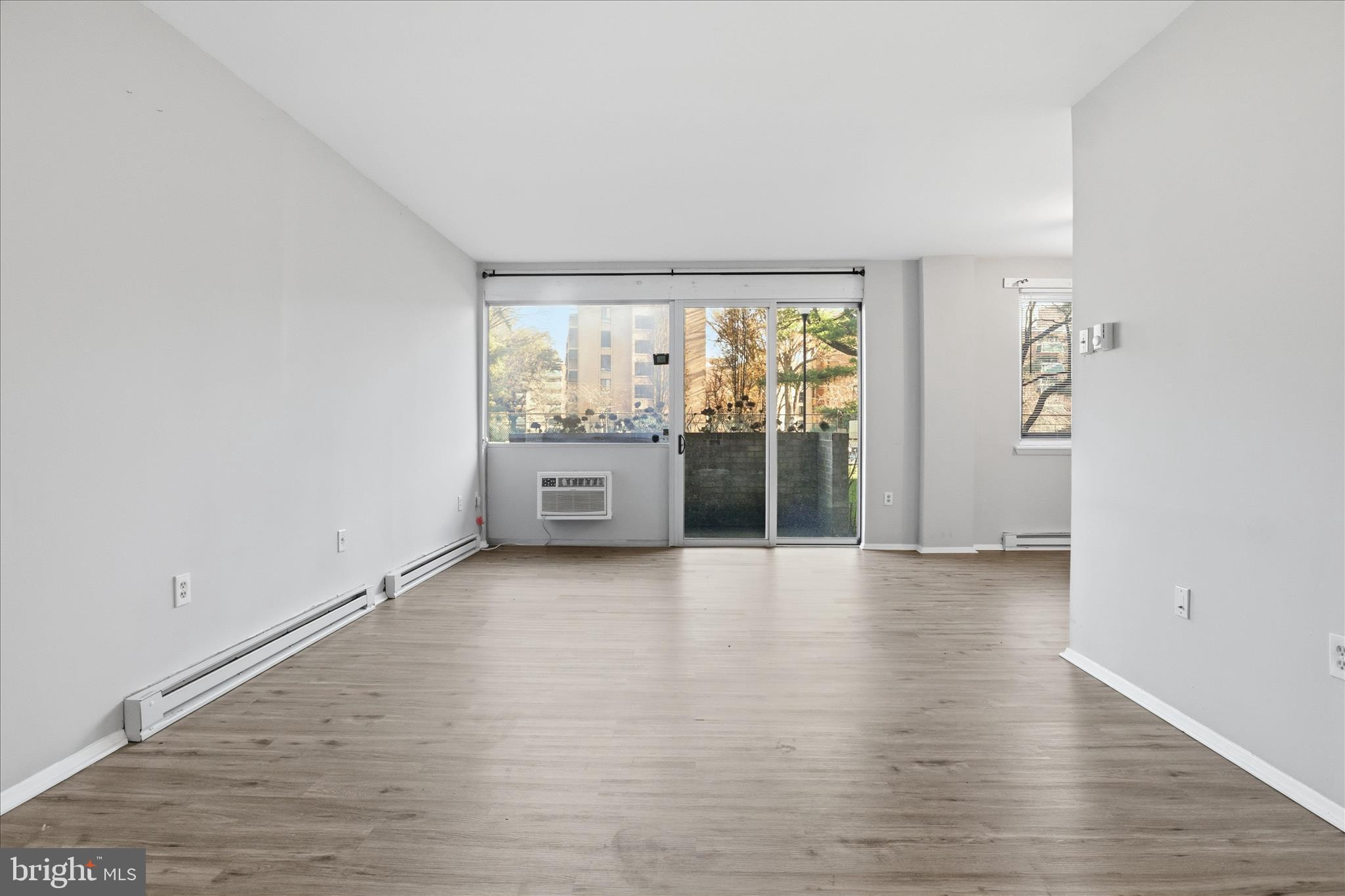3245 Rio Drive, Unit 107 Falls Church, VA 22041 - Photo 4 of 32 a view of an empty room with wooden floor and a window