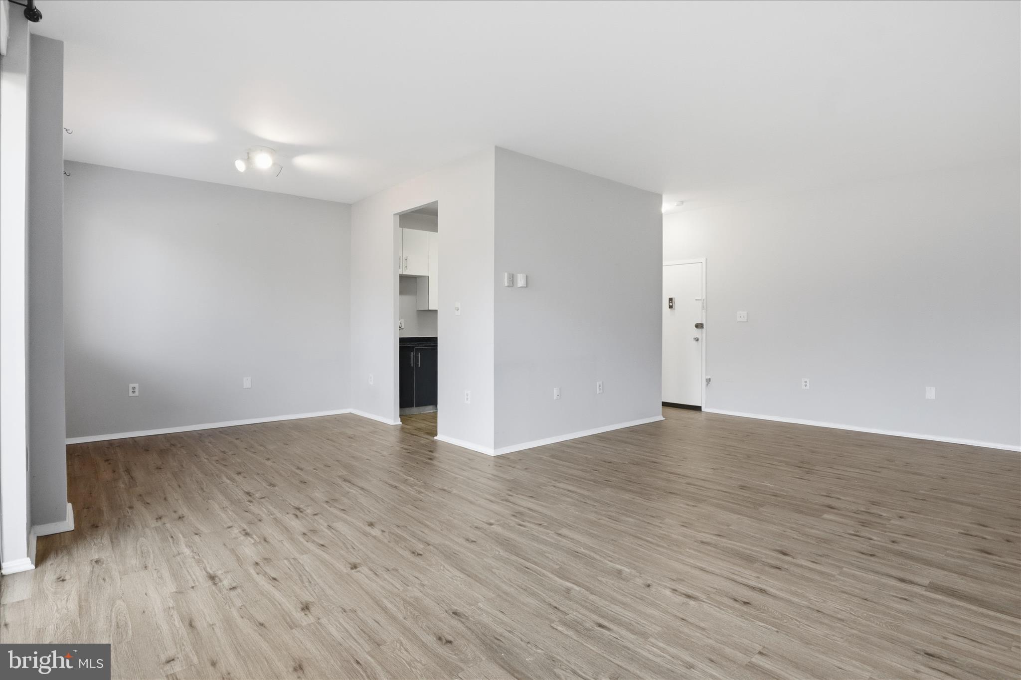 3245 Rio Drive, Unit 107 Falls Church, VA 22041 - Photo 6 of 32 a view of an empty room with wooden floor and a window