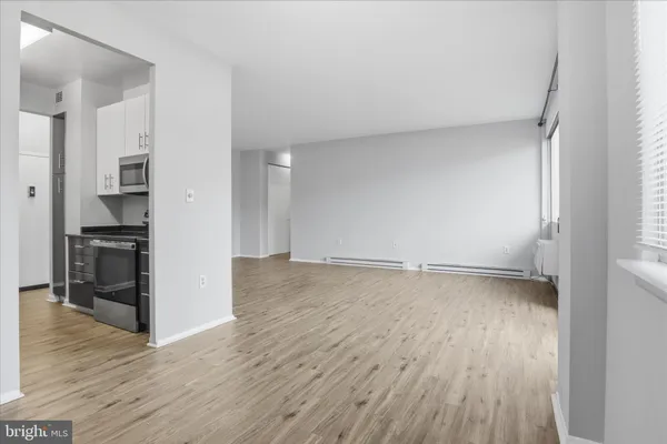 an empty room with wooden floor and electronic appliances