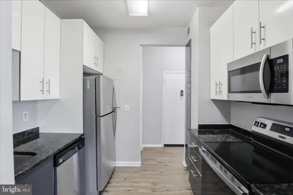 a kitchen with stainless steel appliances granite countertop a refrigerator and a stove top oven