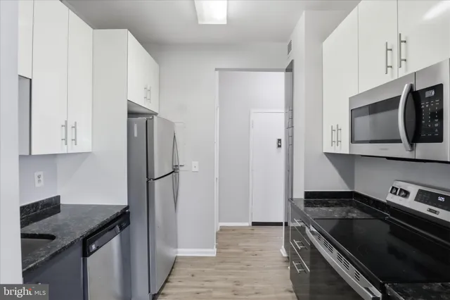 a kitchen with stainless steel appliances granite countertop a refrigerator and a stove top oven
