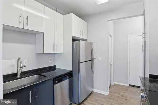 a kitchen with stainless steel appliances a sink a refrigerator and cabinets