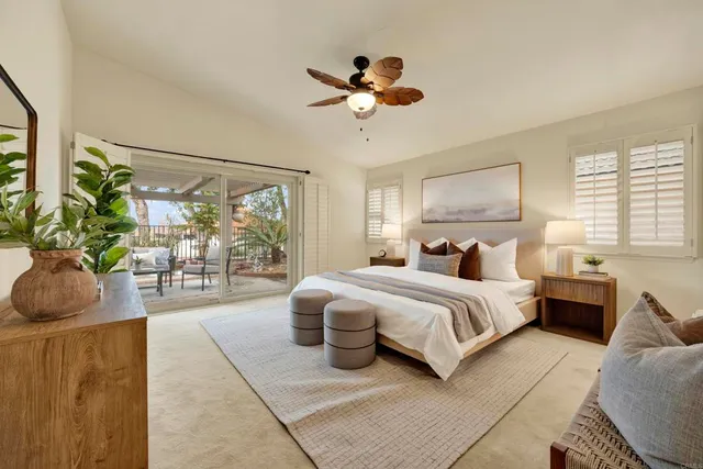 a spacious bedroom with a bed a couch and a chandelier