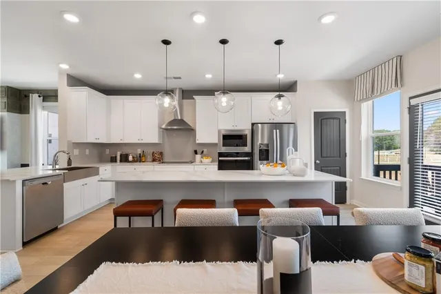 a large white kitchen with stainless steel appliances lots of white cabinets