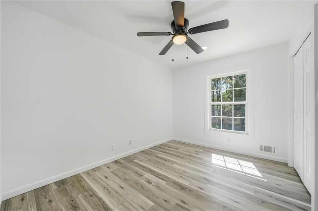 3920 Wedgefield Circle Decatur, GA 30035 - Photo 11 of 25 an empty room with wooden floor fan and windows