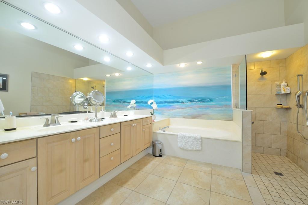 106 Cypress View Drive, Unit C8 Naples, FL 34113 - Photo 11 of 30 a bathroom with a sink a large mirror and a bathtub