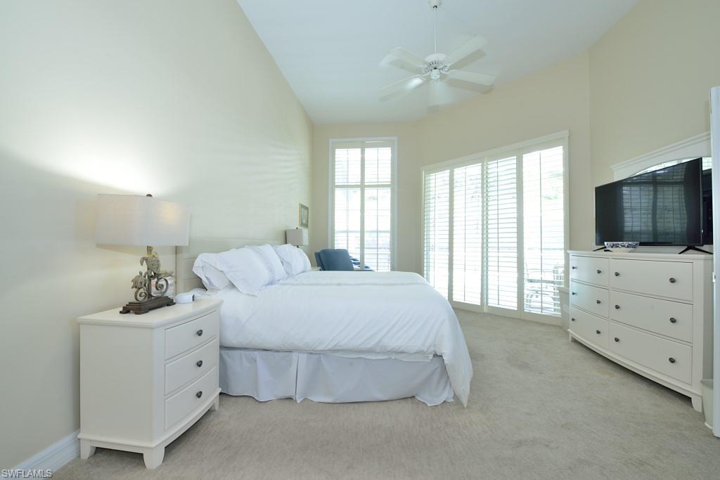 106 Cypress View Drive, Unit C8 Naples, FL 34113 - Photo 12 of 30 a spacious bedroom with a bed and a flat screen tv