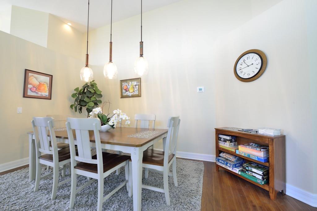 106 Cypress View Drive, Unit C8 Naples, FL 34113 - Photo 6 of 30 a view of a dining room with furniture and wooden floor