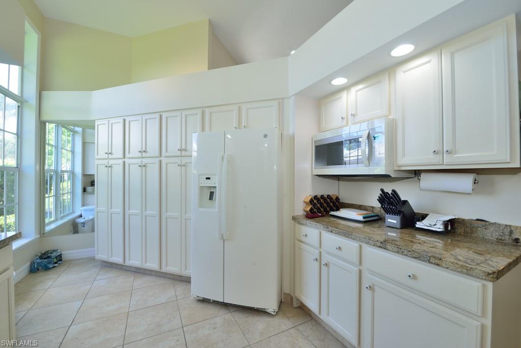 106 Cypress View Drive, Unit C8 Naples, FL 34113 - Photo 8 of 30 a kitchen with stainless steel appliances granite countertop a refrigerator and a sink