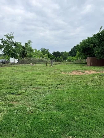 a view of field with grass and trees in the background