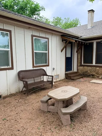a backyard of a house with barbeque oven table and chairs