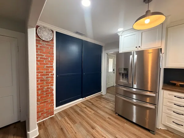 a kitchen with a refrigerator and a wooden floor