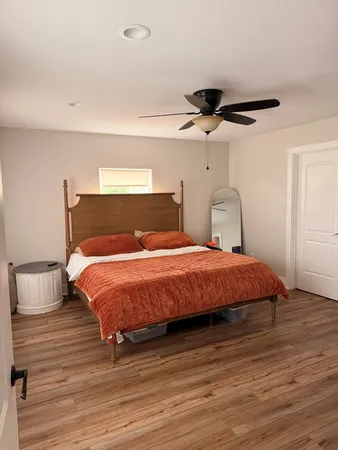 a bedroom with a bed and wooden floor