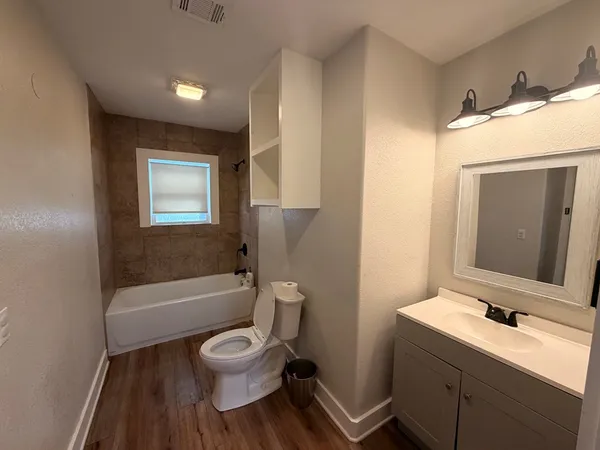 a bathroom with a toilet sink tub and mirror