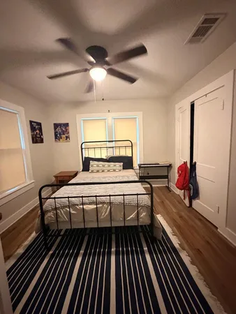 a bedroom with a bed and wooden floor