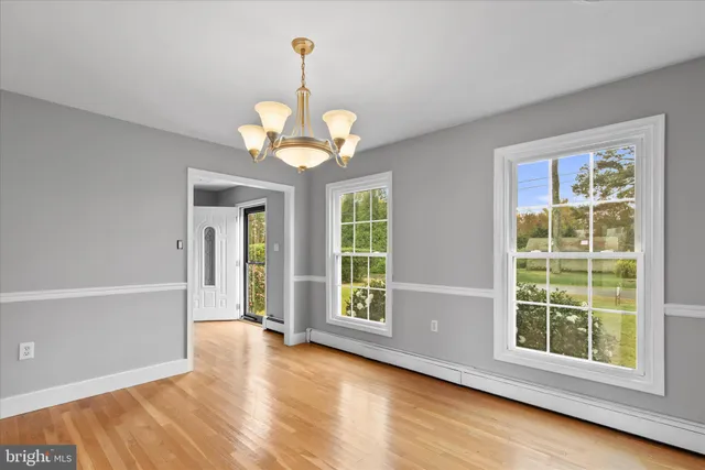 a view of a room with wooden floor and a chandelier