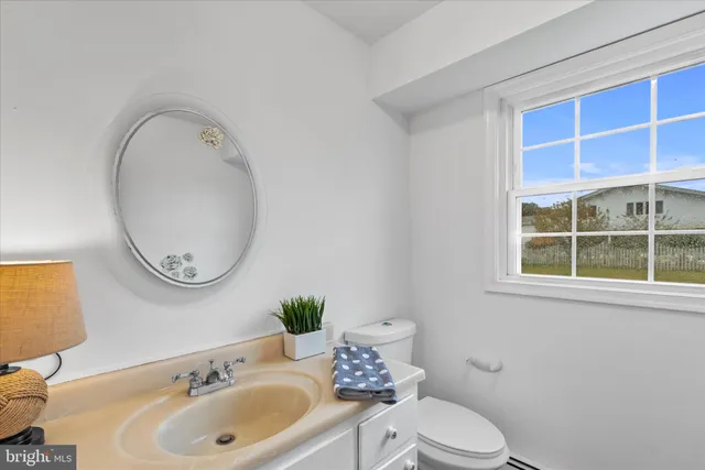 a view of an empty room with wooden floor and windows