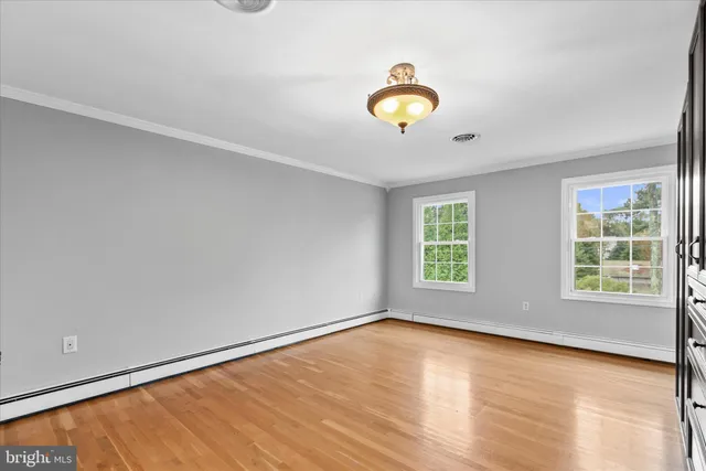 an empty room with windows and cabinet