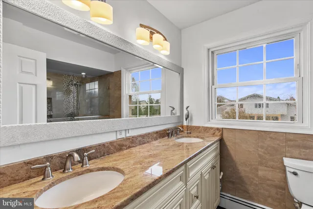 a view of a big room with windows and chandelier fan