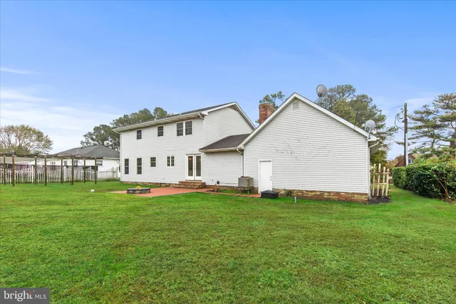 a white house with a big yard and large trees