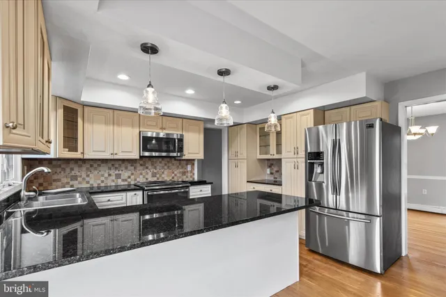 a kitchen with stainless steel appliances granite countertop a sink and a refrigerator