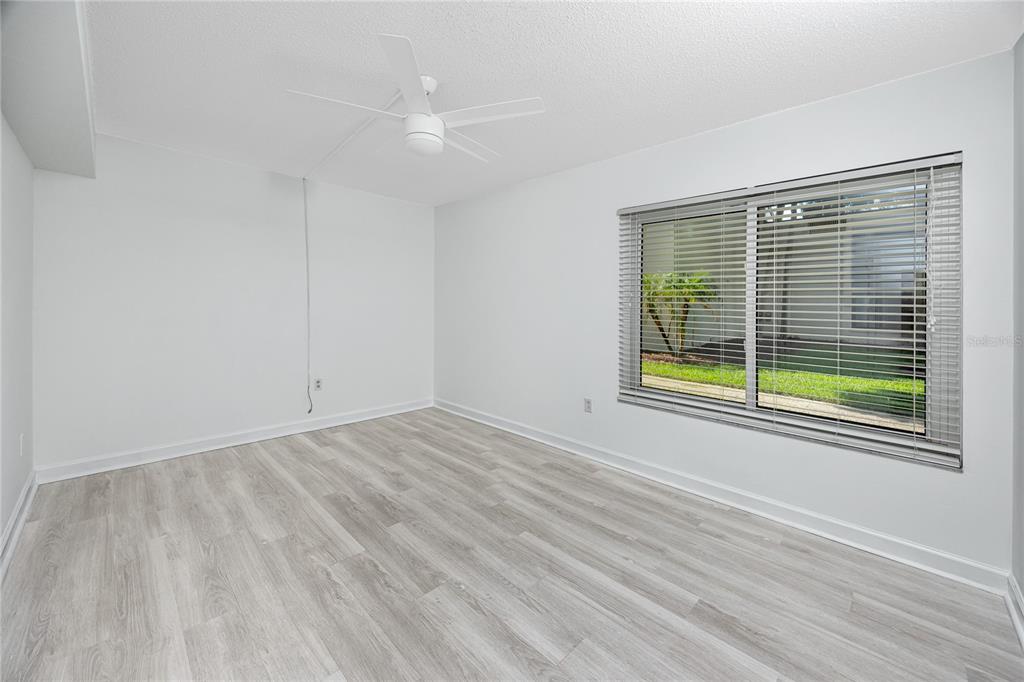 2207 Belleair Road, Unit B4 Clearwater, FL 33764 - Photo 13 of 37 a view of an empty room with wooden floor and a window