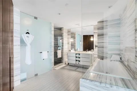 a spacious bathroom with a tub sink and mirror