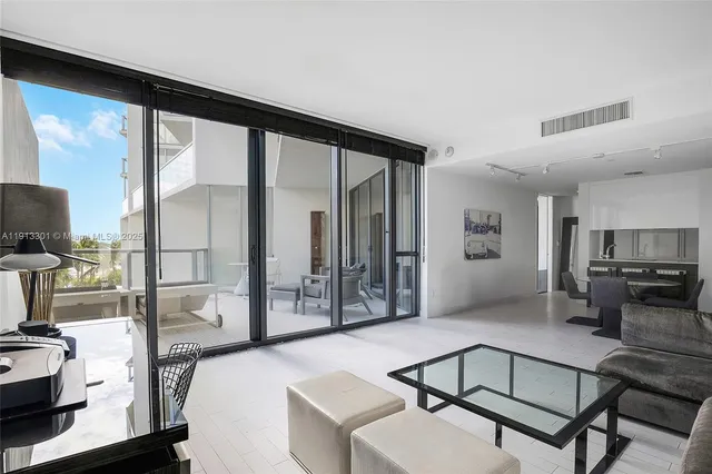 a living room with furniture a flat screen tv and a floor to ceiling window
