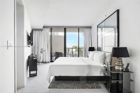 a large bedroom with a bed and wooden floor