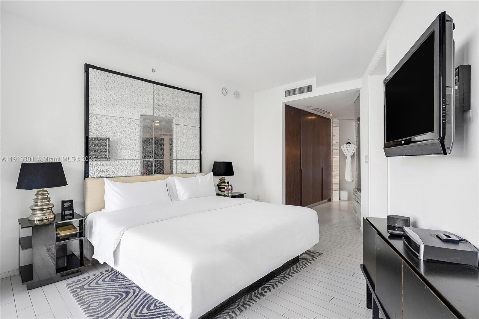 2201 Collins Avenue, Unit 431 Miami Beach, FL 33139 - Photo 10 of 20 a bedroom with a bed and a flat tv screen on a dresser